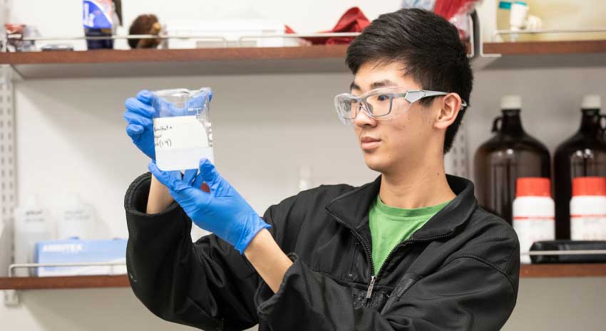 young man with safety goggles in lab