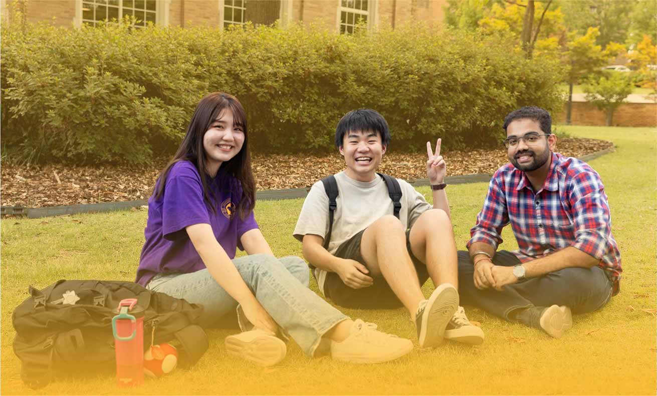 students sitting in grassy area