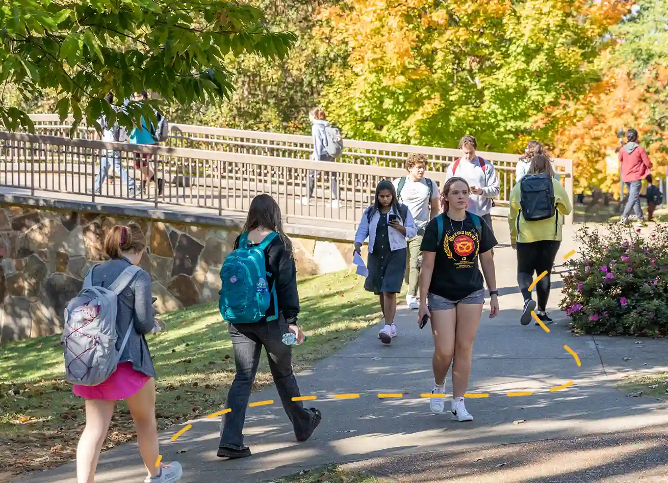 students walking on beautiful green campus grounds